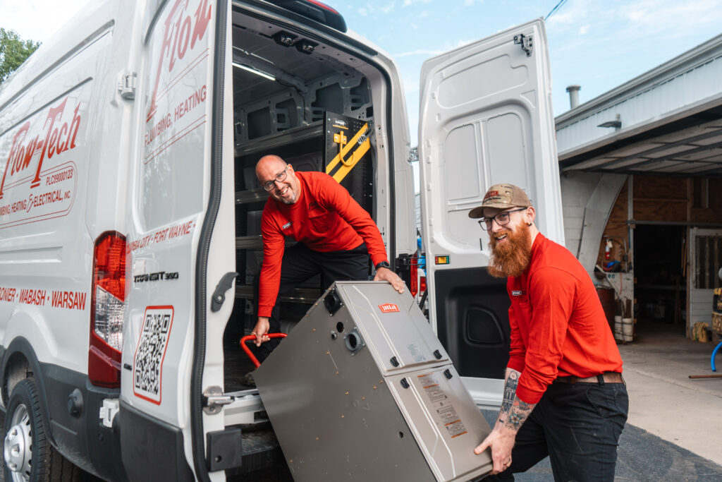 Two Flow-Tech team members unloading equipment from a service van